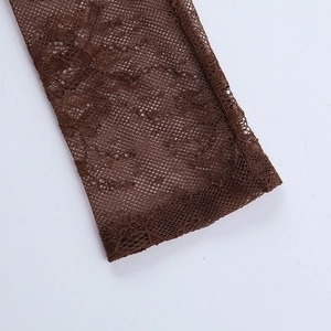 Detailed close-up of dark brown lace mesh fabric with fine floral embroidery and stitching