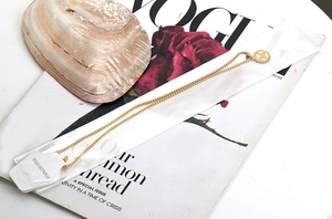 Détail du collier avec pendentif lettre M en acier inoxydable plaqué or 18 carats sur magazine