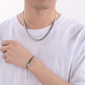 Minimalist silver flat snake chain necklace and bracelet set worn by a fashion model