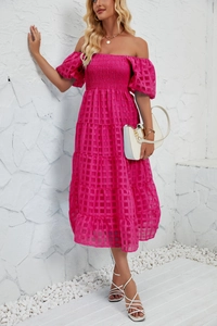 Detail of fuchsia off-shoulder tiered dress showing bubble sleeves and grid texture