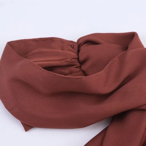 Détail de la robe midi marron foncé avec plis élastiques et texture mousseline douce