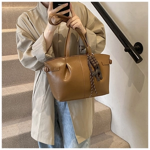 Brown pleated leather tote bag featuring a decorative chocolate charm and textured finish