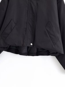 Detail of black cropped hooded jacket showing large pockets and silver snap buttons