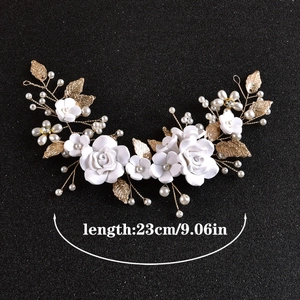 Detail of 23cm bridal hair comb featuring white ceramic flowers and golden leaves