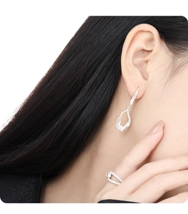 Close-up of S925 sterling silver earrings with irregular texture and artistic hollow design