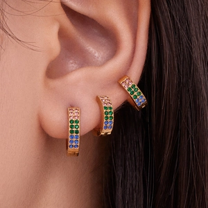 Three-piece set of gold plated zircon earrings with pink green and blue stones on ear