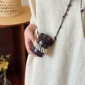 Detail of handmade ethnic coconut shell bag with white beads and zip closure