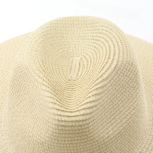 Macro detail of high-quality woven straw fibers on the crown of a beige sun hat
