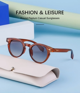 Detail of amber tortoiseshell oval sunglasses with gradient lenses and leather pouch