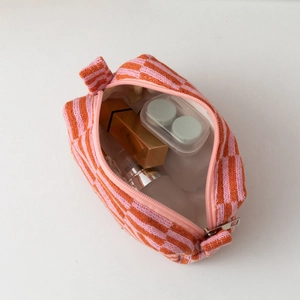 Detail view of large knit makeup bag showing pink and orange checkerboard texture
