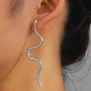 Close-up of wavy snake-shaped earring in silver stainless steel on model's ear