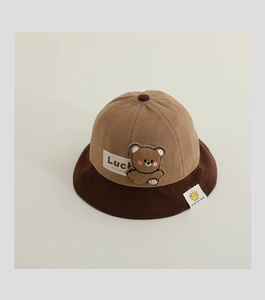 Detail of baby corduroy sun hat with bear embroidery and lucky text in brown tones