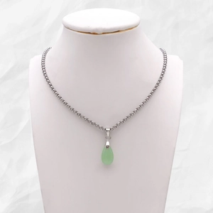 Silver necklace with green teardrop pendant displayed on a white mannequin bust