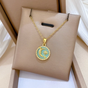 Detailed shot of gold celestial necklace with crescent moon and stars in a jewelry box