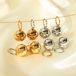 Polished hollow sphere drop earrings in 18K gold and silver plating on satin background