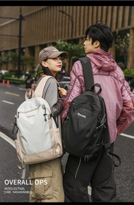 Black and beige durable nylon backpacks shown in a stylish outdoor urban street setting