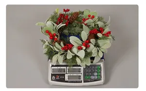 Close-up of a frosted Christmas wreath with red berries and pine cones for home decor
