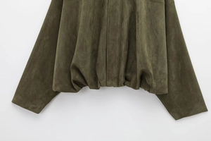 Detailed close-up of dark olive green suede bomber jacket showing fabric texture and hem