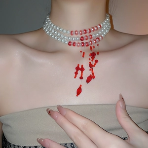 Detail showing elegant multi-layer white pearl and red bead choker with tassel design