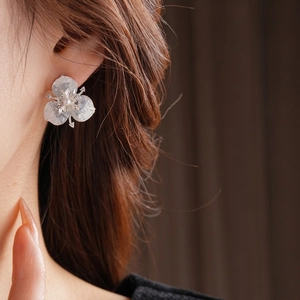 Floral stud earrings with pearl center and crystal petals on model for elegant look