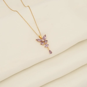 Elegant gold stainless steel necklace with a purple crystal butterfly pendant on silk fabric
