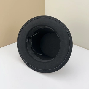 Detail of wool felt top hat interior showing black sweatband and fabric care label