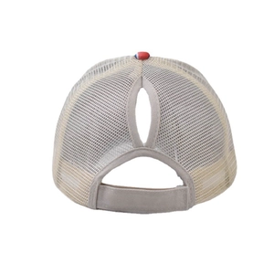 Detail showing the ponytail hole and adjustable velcro strap on light beige mesh cap