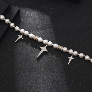 Hip hop pearl and metal necklace with silver cross pendants on a black background