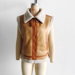 Detail of brown faux leather vest featuring white faux shearling lining and collar buckle