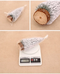 Detailed view of the 45g snowy Christmas tree miniature with a rustic wooden base