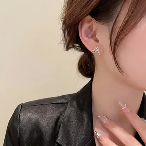 Elegant silver knot earrings with micro-p镶 zirconias worn on a female model