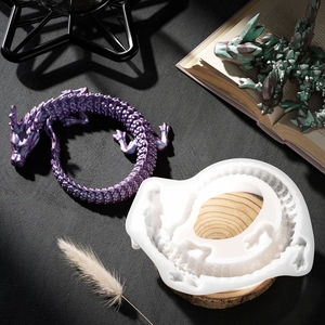 Detailed translucent dragon silicone mold with finished resin art on black stone background