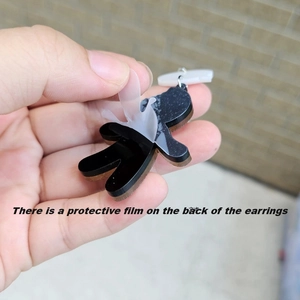 Detail showing the protective film being removed from the back of acrylic bear earrings