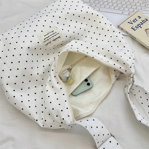 Internal view of polka dot canvas tote showing zipper pocket and storage capacity