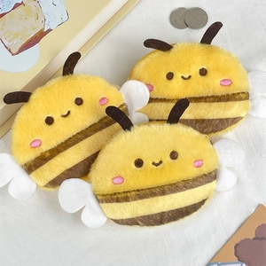 Close-up of cute plush bee coin purses with soft fur texture and embroidered details