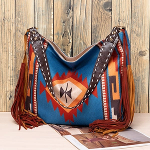 Close-up of blue Bohemian woven tote bag with tribal patterns and long leather tassels