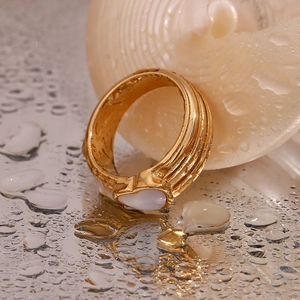 Detailed close-up of 18K gold-plated wide ring with heart shell inlay on wet surface