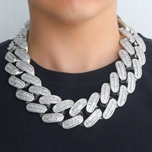 Close-up of 15mm silver Cuban link necklace with zircon stones worn by a model