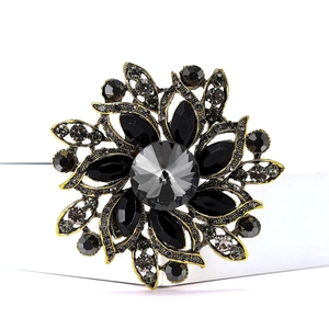 Macro view of vintage flower brooch featuring dark crystals and bronze metal finish