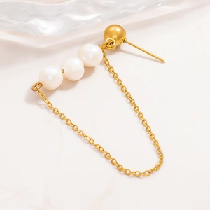 Detail of 18k gold earrings featuring three natural pearls and fine chain tassels