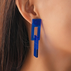 Close-up of blue geometric acrylic drop earrings with two linked rectangular chain links