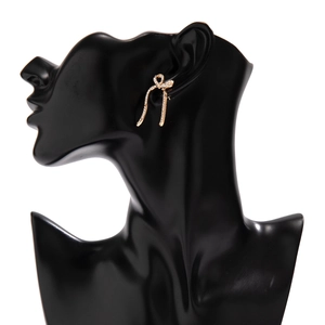 Detail view of golden bow earrings with rhinestone tassels on a jewelry display