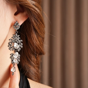 Nahaufnahme von Vintage-Quastenohrringen mit glitzernden Kristallen am Modell