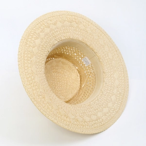 Detailed interior texture and weave of a beige wide-brim handmade straw sun hat