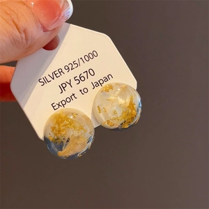 Detailed close-up of S925 sterling silver earring with gold foil in resin inlay