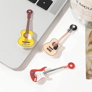 Detailed macro view of acrylic guitar-shaped hair clips in yellow, wood, and red colors