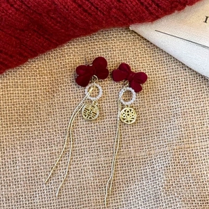 Detailed shot of festive red bow earrings with pearl ring and golden Xi character pendant