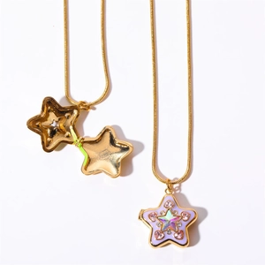 Dettaglio di ciondoli a stella Y2K dorati con strass rosa e design traforato su fondo bianco