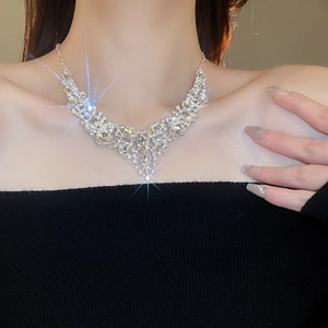 Close-up of sparkling rhinestone tassel necklace worn with an elegant black evening dress
