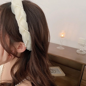 Detail of cream organza headband featuring elegant pleats and white faux pearl accents
